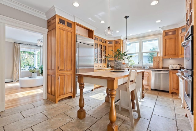 kitchen with glass insert cabinets, a center island, stainless steel appliances, and decorative light fixtures