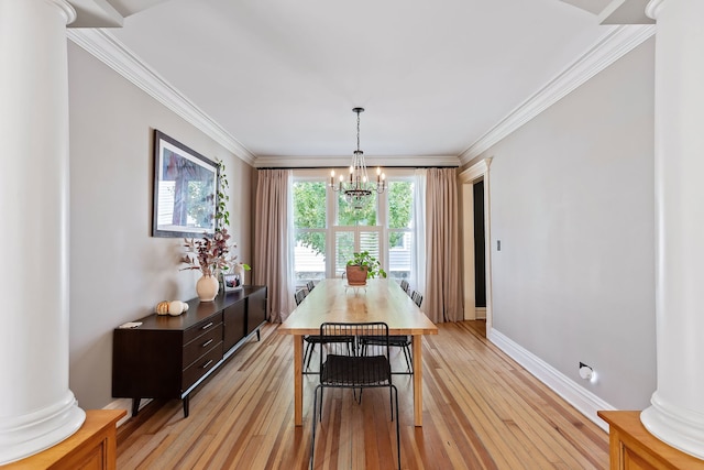 dining room with ornamental molding, light wood-style flooring, and ornate columns