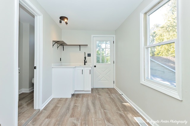 interior space featuring light hardwood / wood-style floors, sink, and plenty of natural light