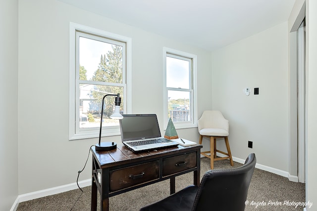 office space featuring plenty of natural light and dark colored carpet