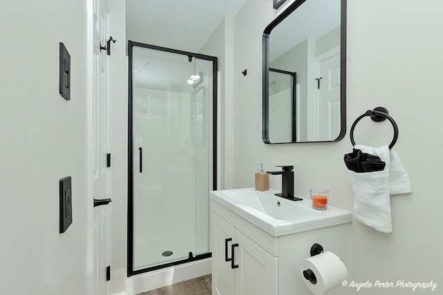 bathroom with vanity, wood-type flooring, and a shower with door