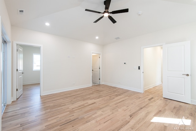 spare room featuring ceiling fan, lofted ceiling, and light wood-type flooring