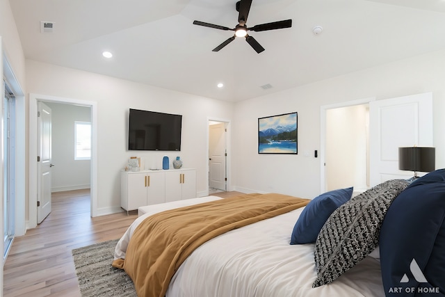 bedroom with vaulted ceiling, light hardwood / wood-style floors, and ceiling fan