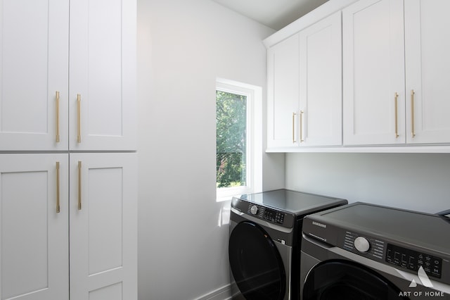 laundry area featuring washing machine and dryer and cabinets