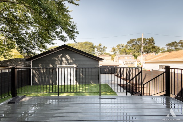 wooden terrace featuring a garage and a lawn