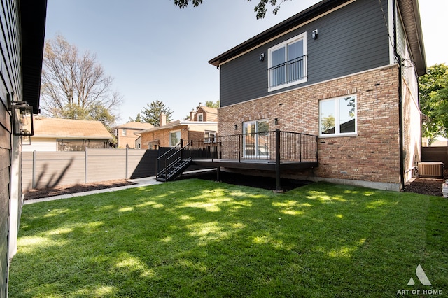 rear view of house with a wooden deck, cooling unit, and a yard