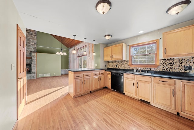 kitchen with light wood-type flooring, black dishwasher, lofted ceiling, kitchen peninsula, and hanging light fixtures