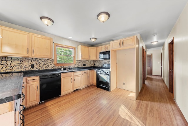 kitchen with light brown cabinetry, light hardwood / wood-style flooring, backsplash, and black appliances