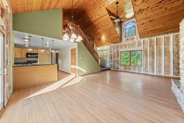 unfurnished living room featuring ceiling fan with notable chandelier, light wood-type flooring, wood ceiling, and high vaulted ceiling