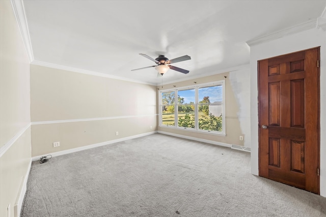 empty room with crown molding, light colored carpet, and ceiling fan