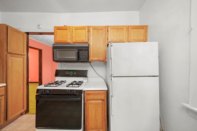 kitchen featuring white fridge, light parquet floors, and range with gas stovetop