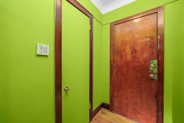 entryway featuring ornamental molding and light wood-type flooring