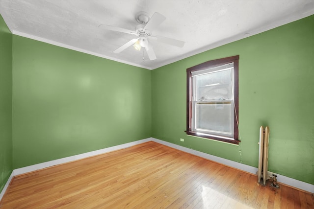 empty room featuring crown molding, radiator, light hardwood / wood-style floors, and ceiling fan