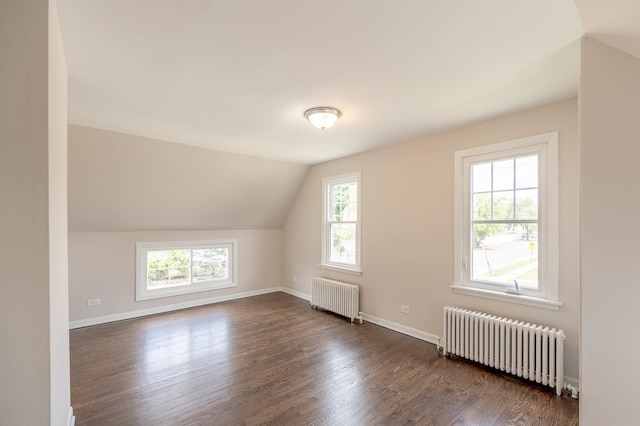 bonus room featuring vaulted ceiling, radiator heating unit, and dark hardwood / wood-style floors