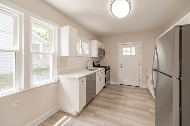 kitchen featuring stainless steel appliances, tasteful backsplash, sink, and white cabinetry