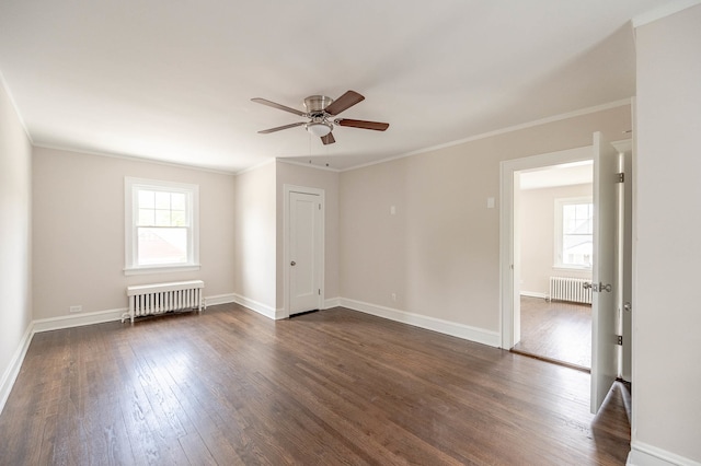 spare room with ceiling fan, crown molding, dark wood-type flooring, and radiator heating unit