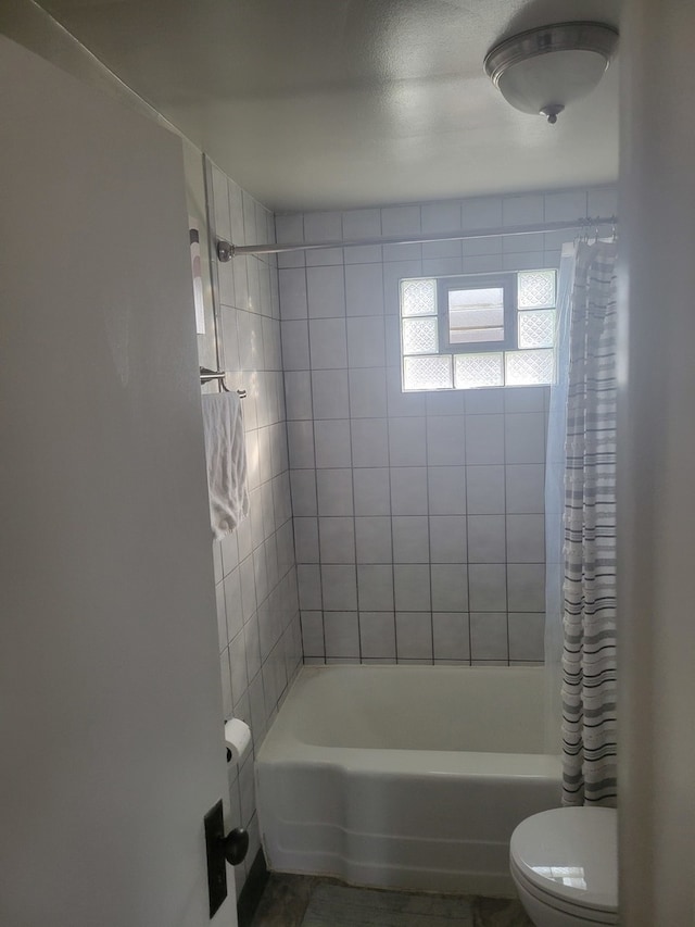 bathroom with shower / bath combo with shower curtain and toilet