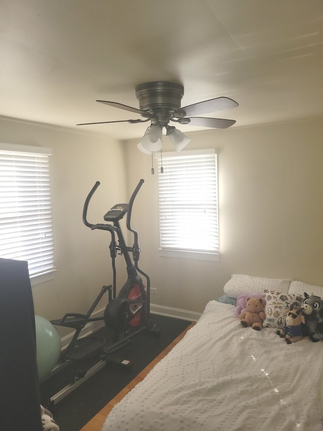 bedroom with multiple windows, ceiling fan, and dark wood-type flooring