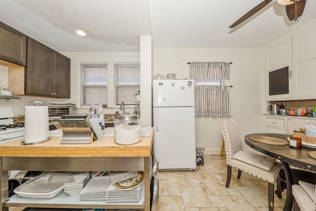 kitchen with dark brown cabinetry, white refrigerator, and tasteful backsplash