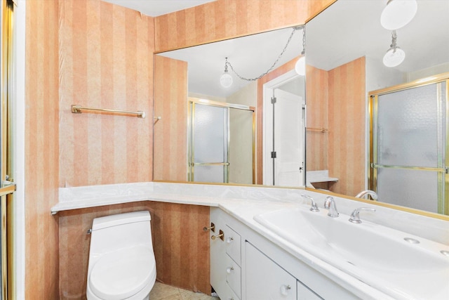 bathroom featuring tile patterned flooring, vanity, toilet, and walk in shower