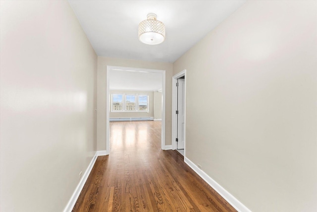 hall with dark hardwood / wood-style floors and a baseboard heating unit