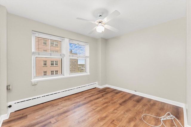 spare room featuring wood-type flooring, a baseboard radiator, and ceiling fan