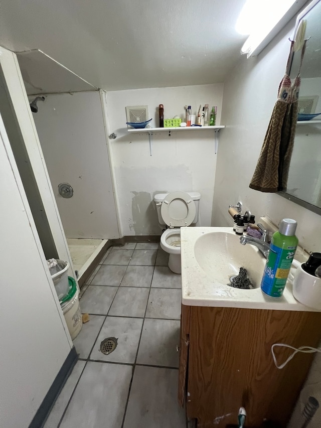 bathroom featuring tile patterned flooring, vanity, walk in shower, and toilet