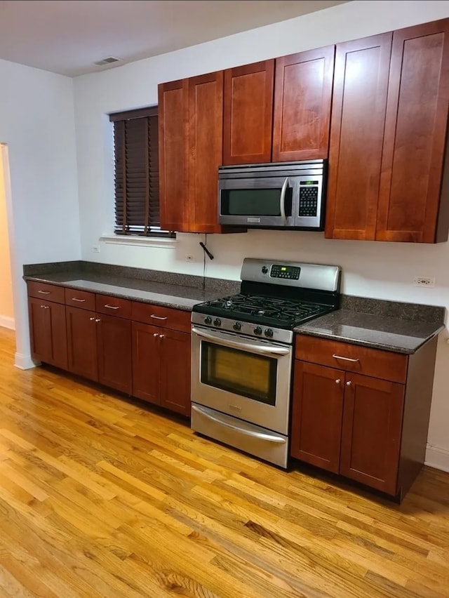 kitchen with stainless steel appliances and light hardwood / wood-style flooring