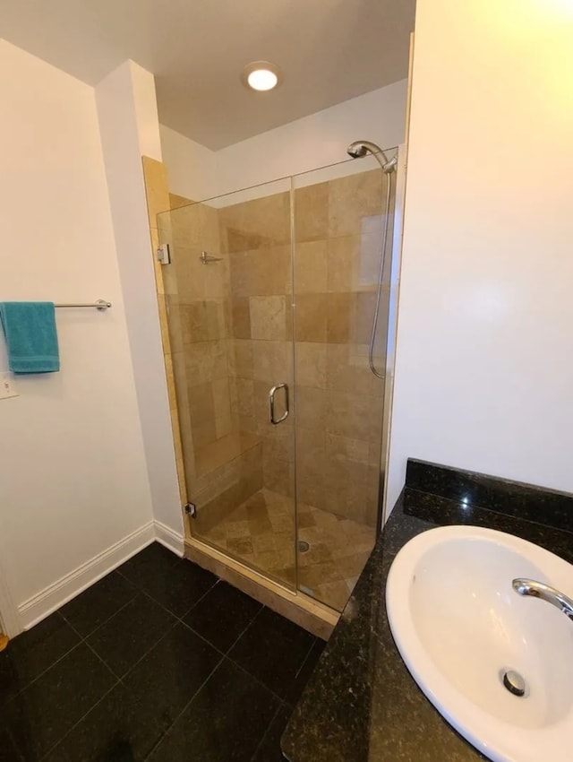 bathroom with walk in shower, tile patterned floors, and sink