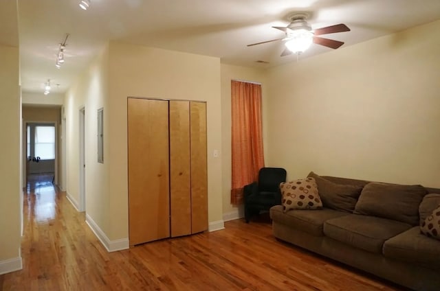 living room with ceiling fan, light wood-type flooring, and rail lighting