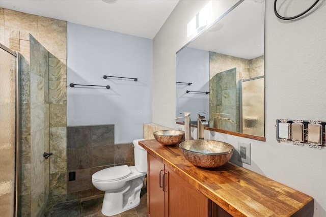 bathroom featuring toilet, walk in shower, vanity, and tile patterned floors