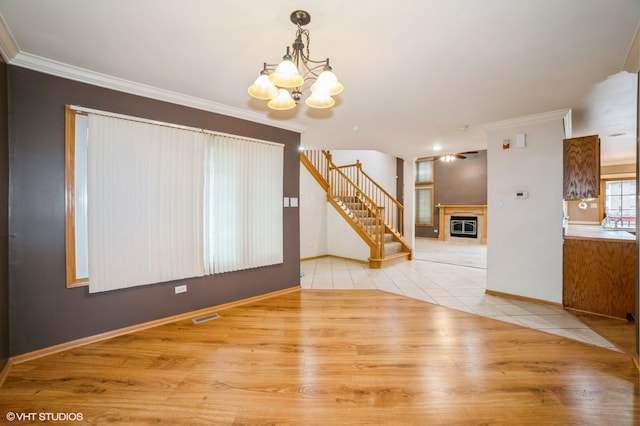 interior space featuring a chandelier, ornamental molding, and light hardwood / wood-style flooring