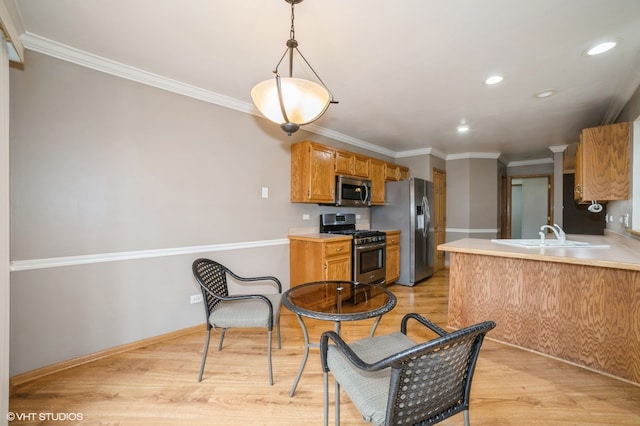 kitchen with stainless steel appliances, light hardwood / wood-style floors, hanging light fixtures, and sink