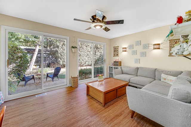 living room featuring plenty of natural light, light hardwood / wood-style floors, and ceiling fan