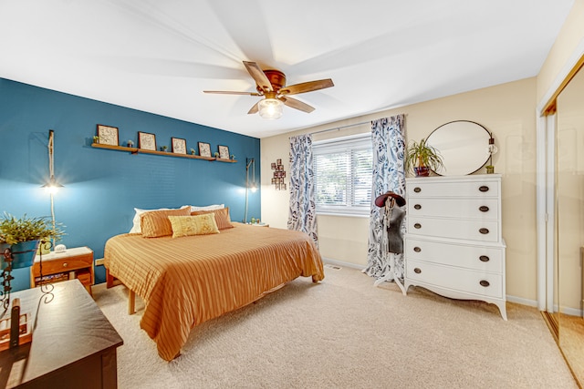 carpeted bedroom with ceiling fan and a closet