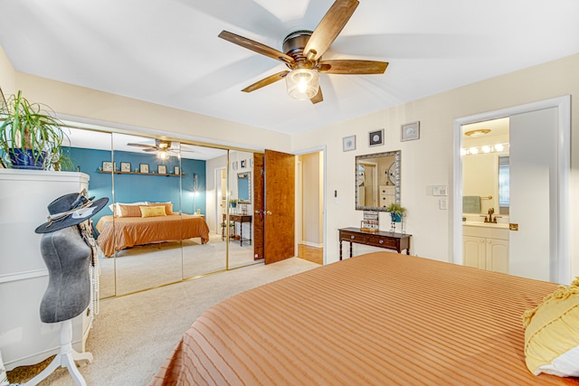 carpeted bedroom with connected bathroom, a closet, and ceiling fan