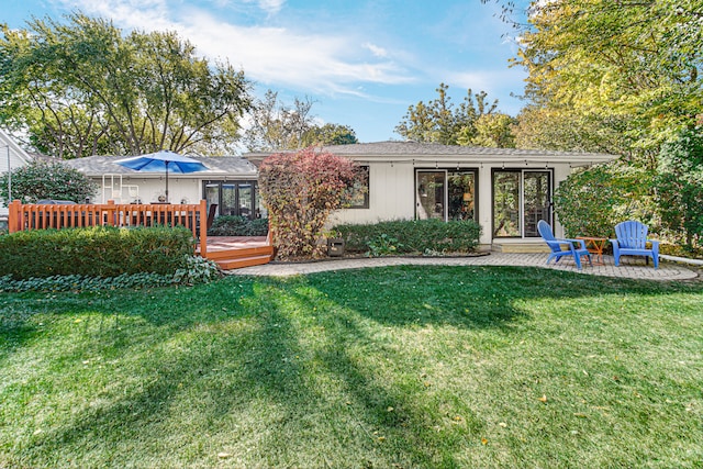 back of property with a lawn and a deck