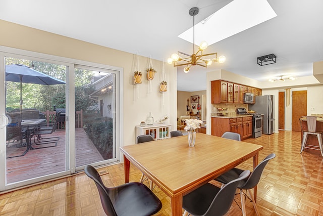 dining area with a chandelier and light parquet flooring