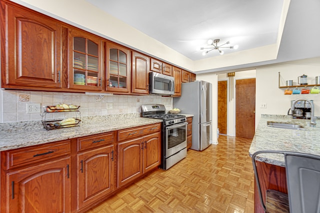 kitchen with backsplash, stainless steel appliances, an inviting chandelier, and sink