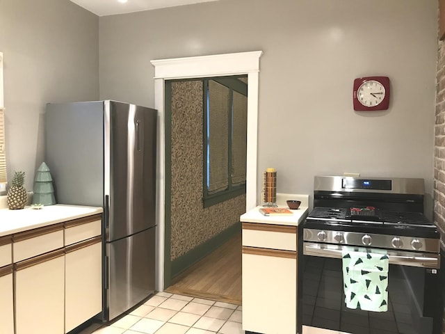 kitchen with white cabinetry, light tile patterned floors, and stainless steel appliances