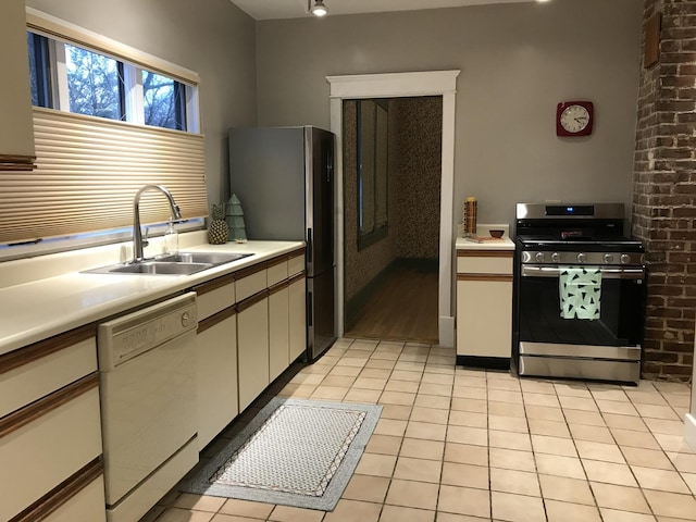 kitchen featuring white cabinets, light tile patterned floors, sink, and appliances with stainless steel finishes