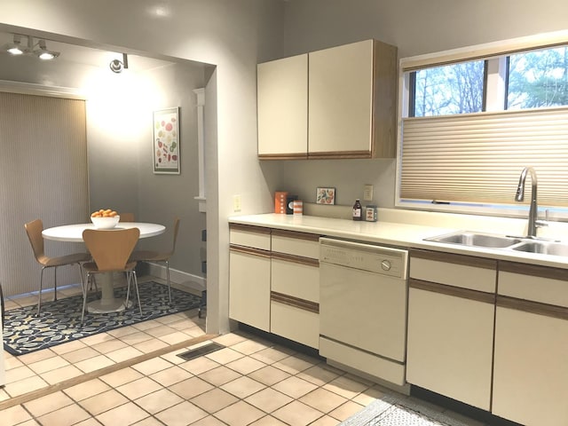 kitchen with dishwasher, light tile patterned floors, and sink