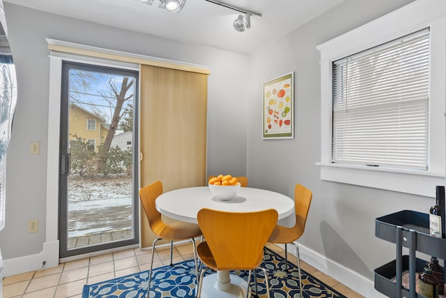 dining area with light tile patterned floors and track lighting