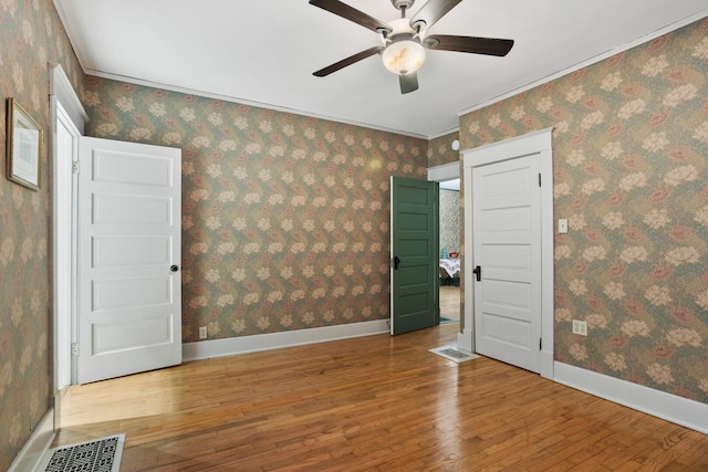 unfurnished room featuring ceiling fan, hardwood / wood-style floors, and ornamental molding