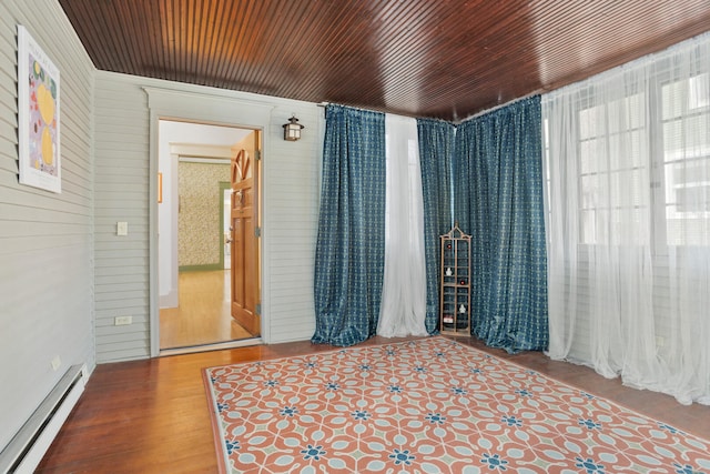 empty room with baseboard heating, a healthy amount of sunlight, and wood ceiling