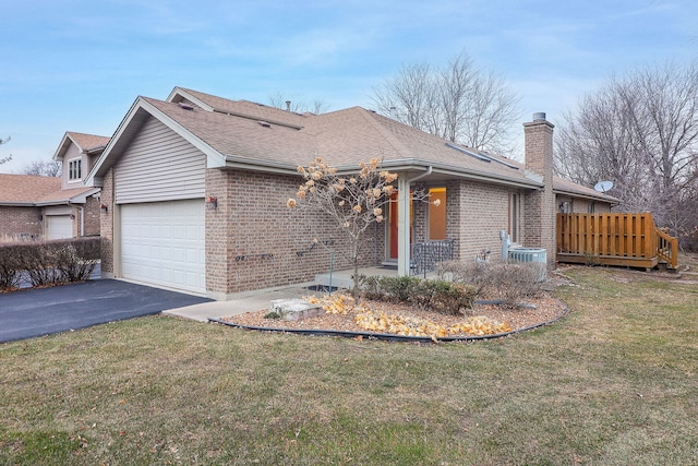 view of front facade with central AC, a garage, and a front lawn