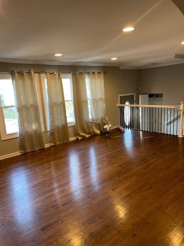 unfurnished room with ornamental molding and dark wood-type flooring