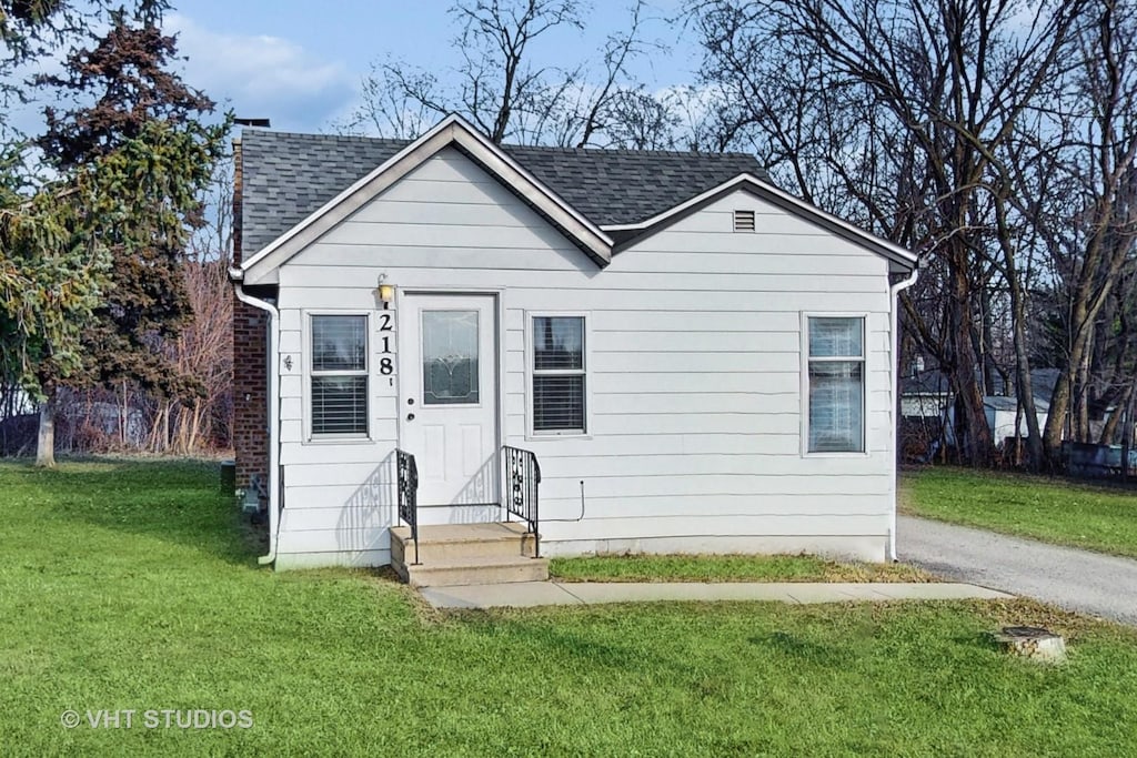 bungalow-style home featuring a front yard