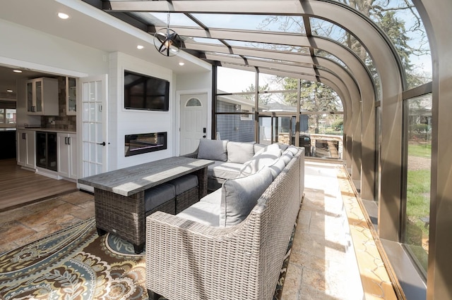 sunroom / solarium with beverage cooler and a fireplace