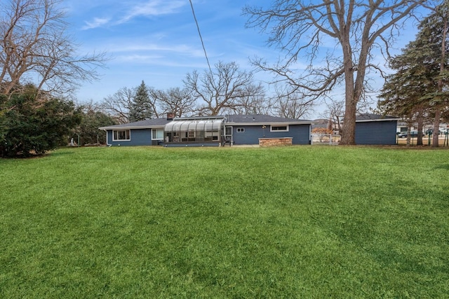 rear view of house featuring a lawn